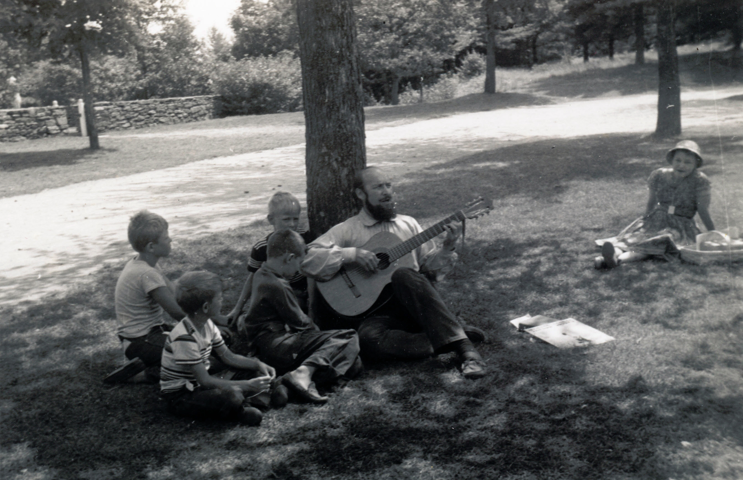 Bill, playing the guitar with an audience of four children